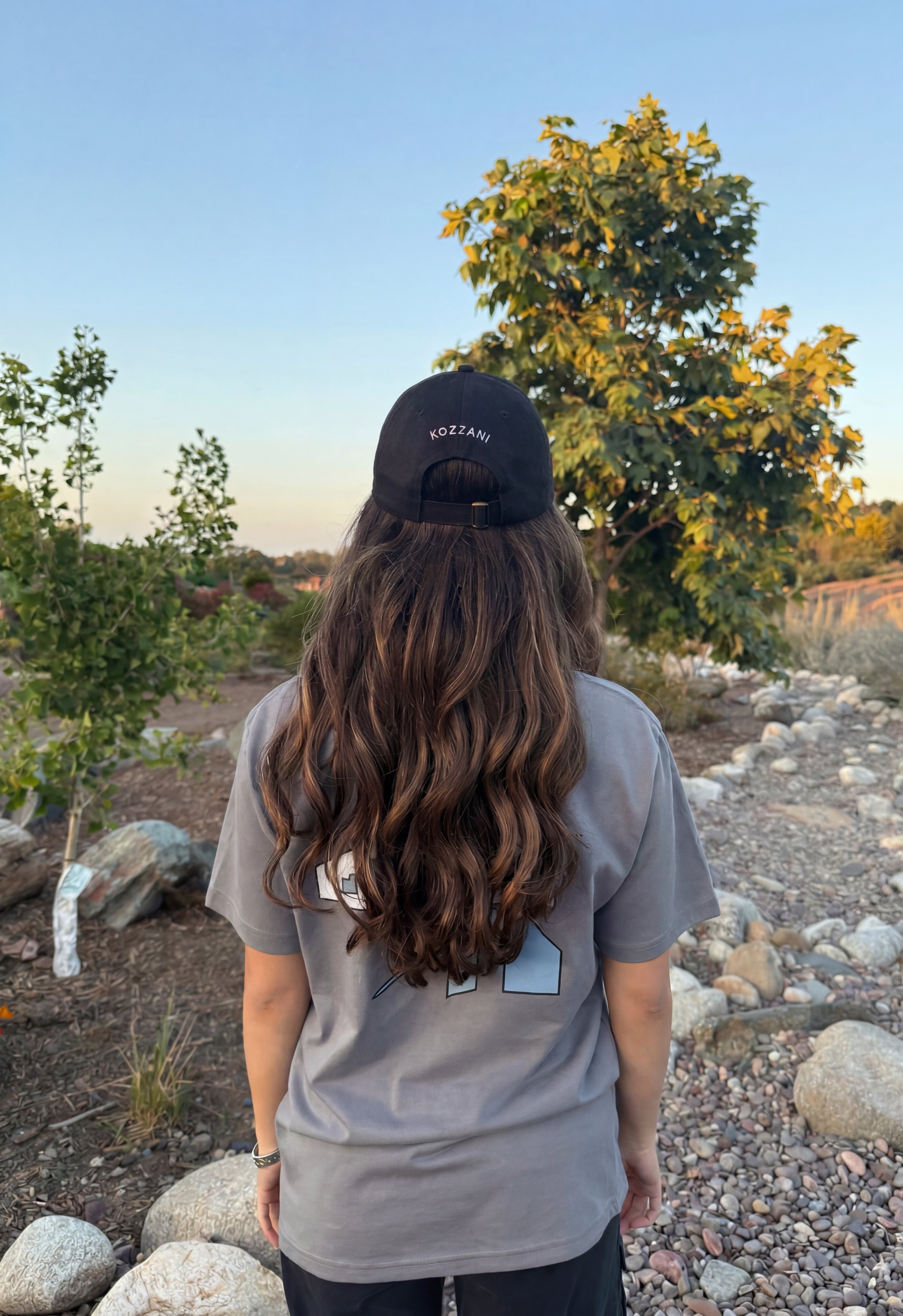 Black baseball cap worn forward with small logo on the crown