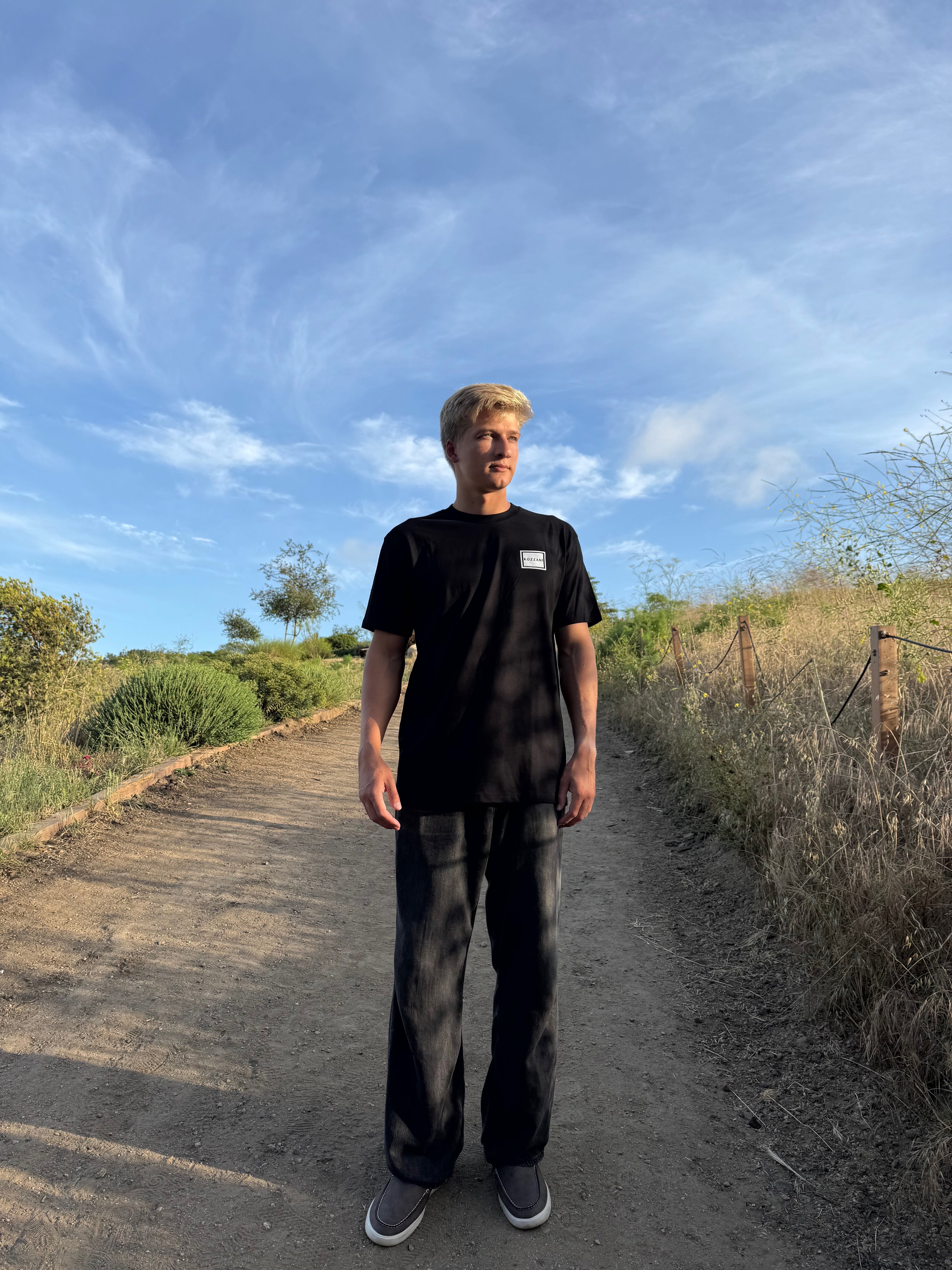Black crew-neck tee with small square geometric logo on chest
