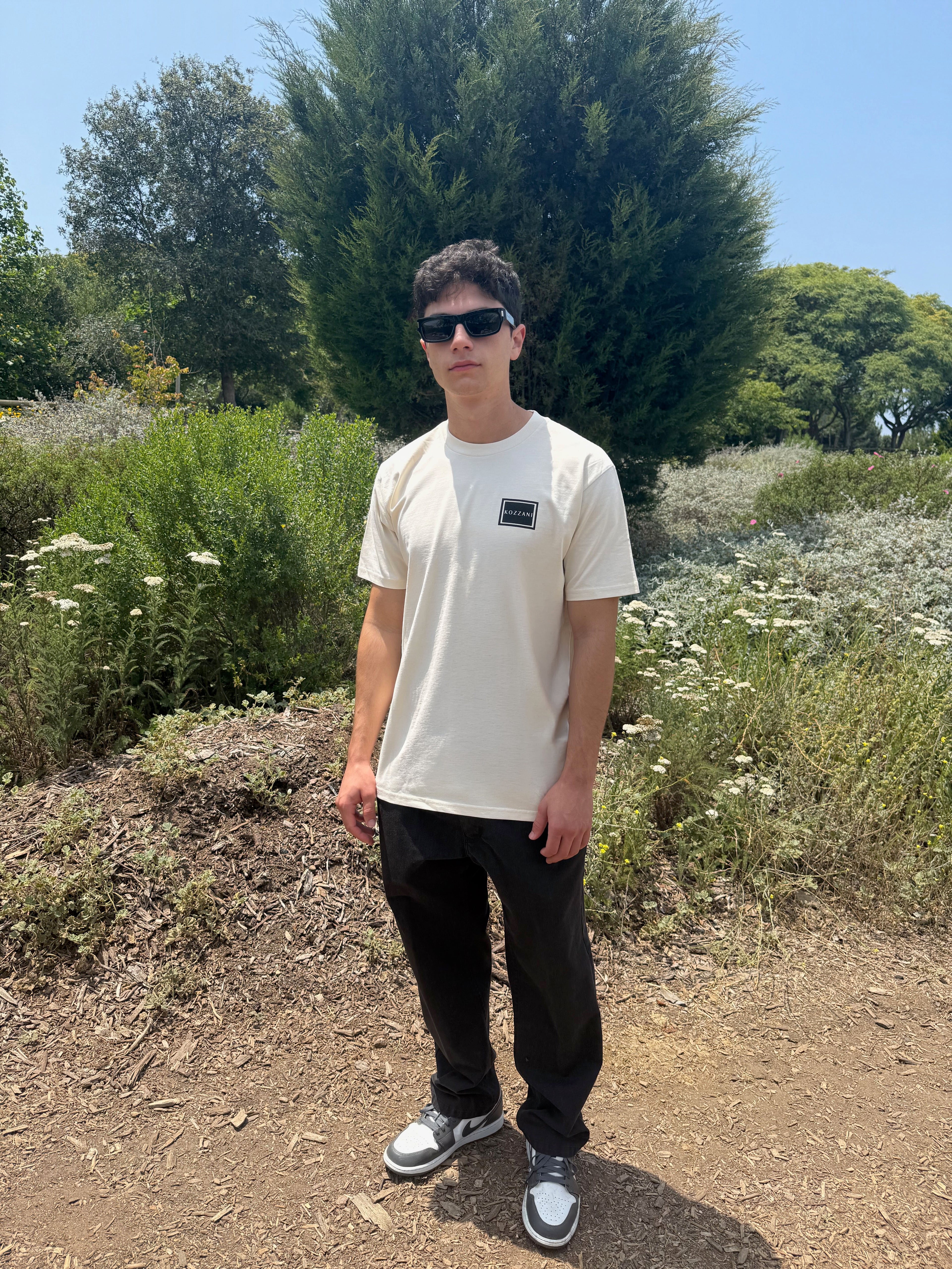 Bone crew-neck tee with small square geometric logo on chest
