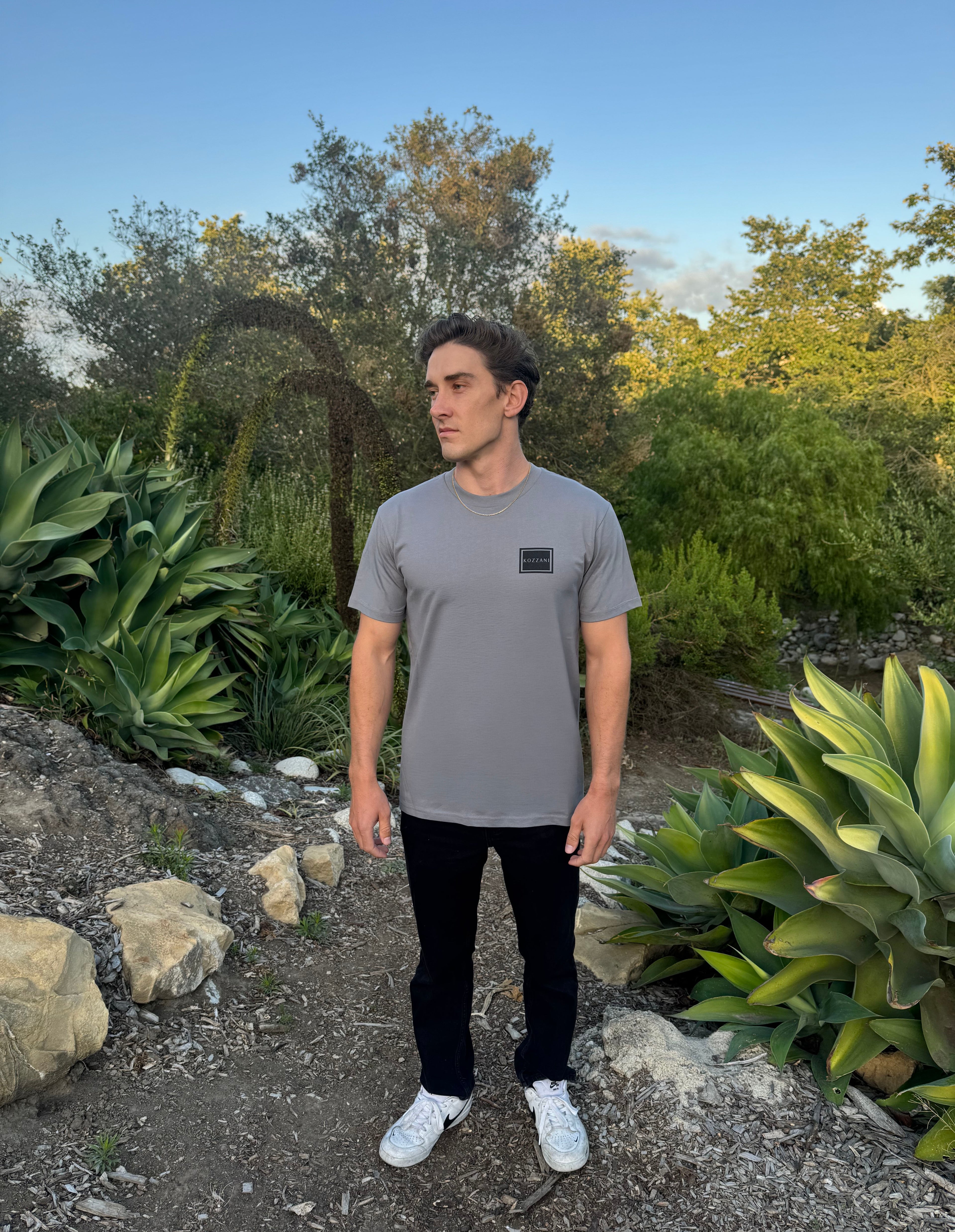 Gray crew-neck tee with small square geometric logo on chest